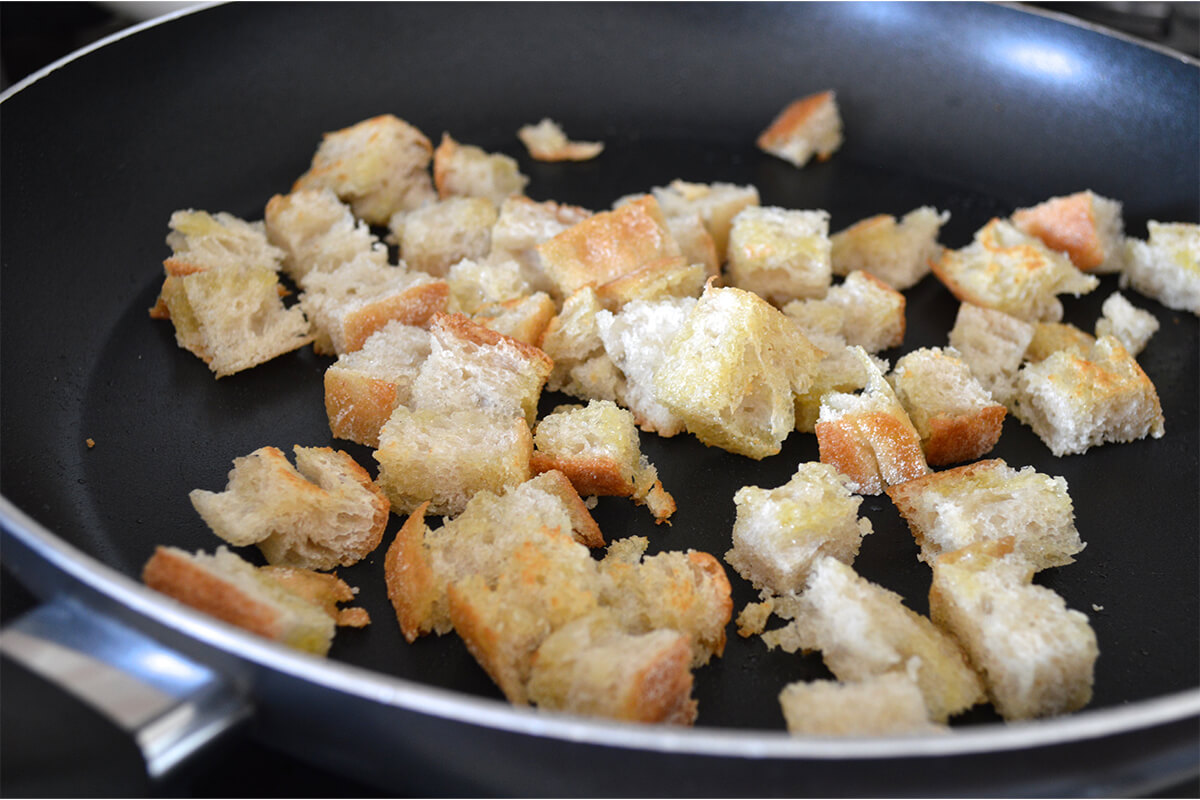 A saucepan of ciabatta pieces being fried