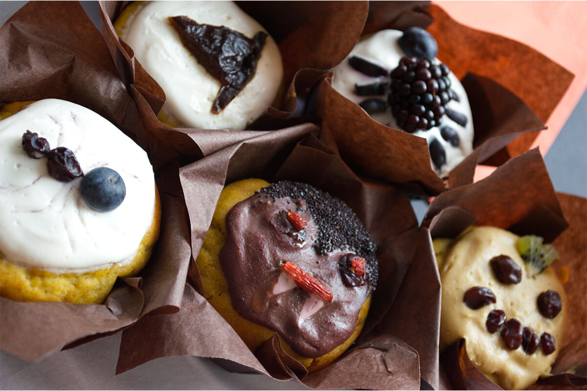 Sweet Halloween Pumpkin Muffins, 2 of them designed to look like spiders, one to look like a pumpkin, another a witches hat and one like Dracula 