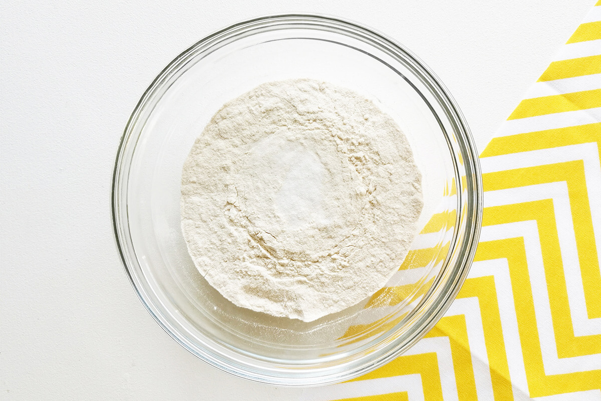 A glass mixing bowl of flour and bicarbonate of soda