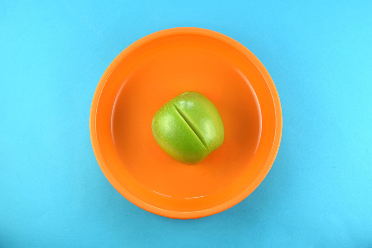 Cored apple placed on plate, cut side down