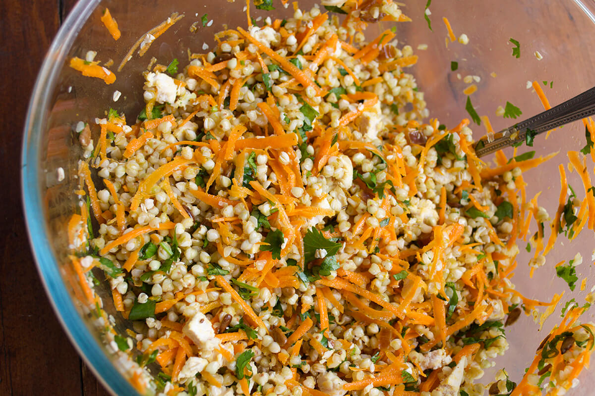 Salad ingredients being mixed in a large bowl 