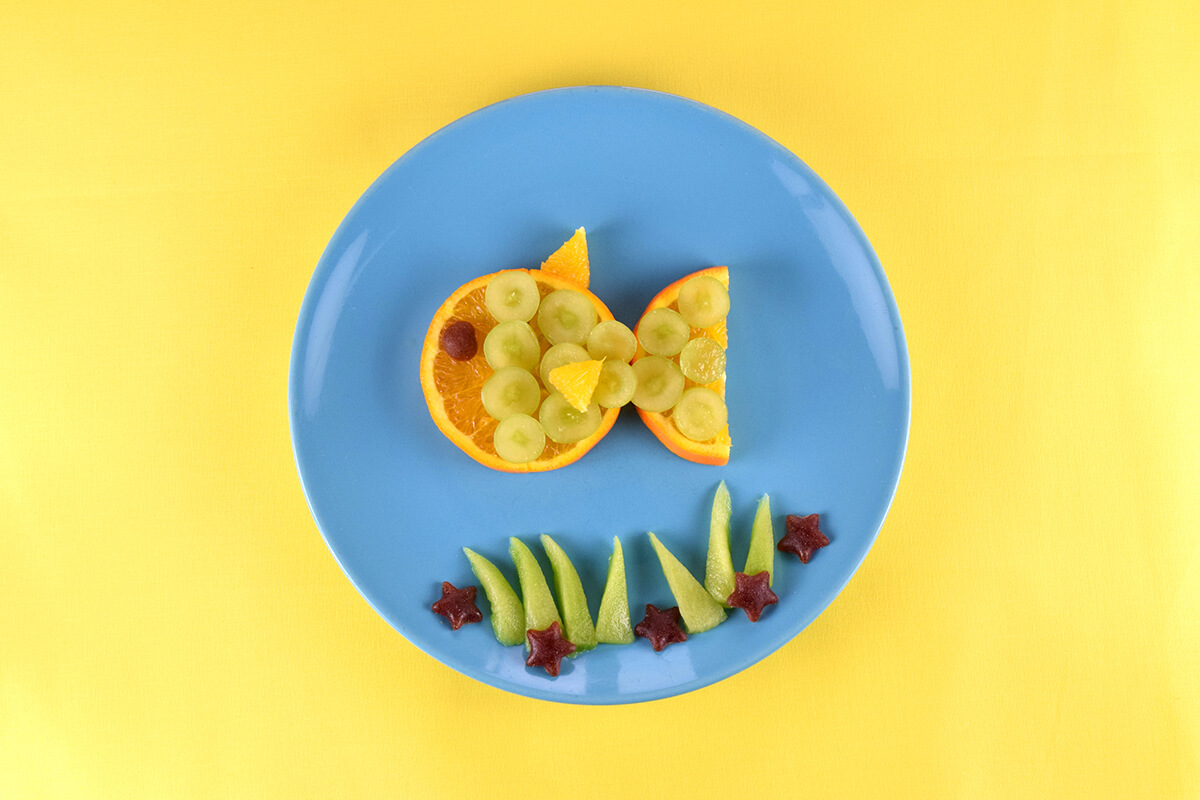 Blackcurrant and apple stars placed in the kiwi fruit seaweed to create starfish. Strawberry and apple gummies placed above the fish to create bubbles 