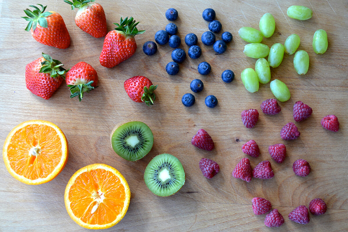 Halved orange and kiwi with strawberries, blueberries, raspberries and grapes