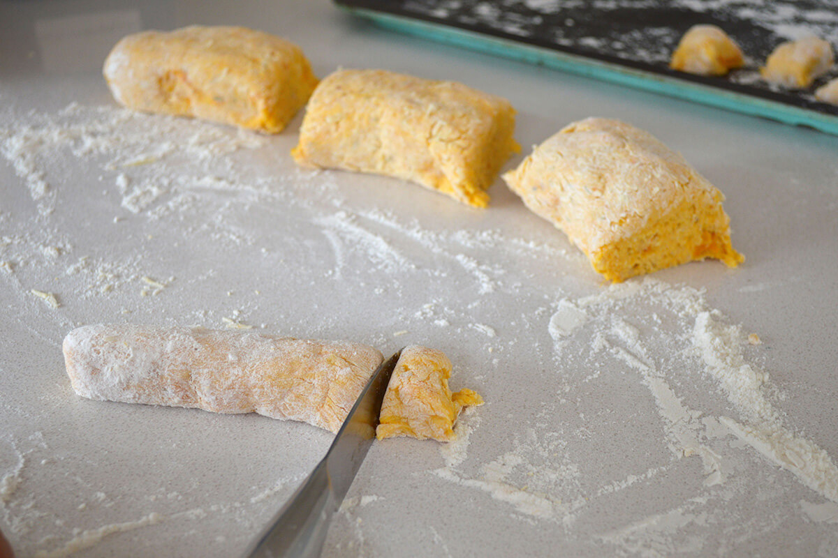 A floured work surface with gnocchi dough being cut