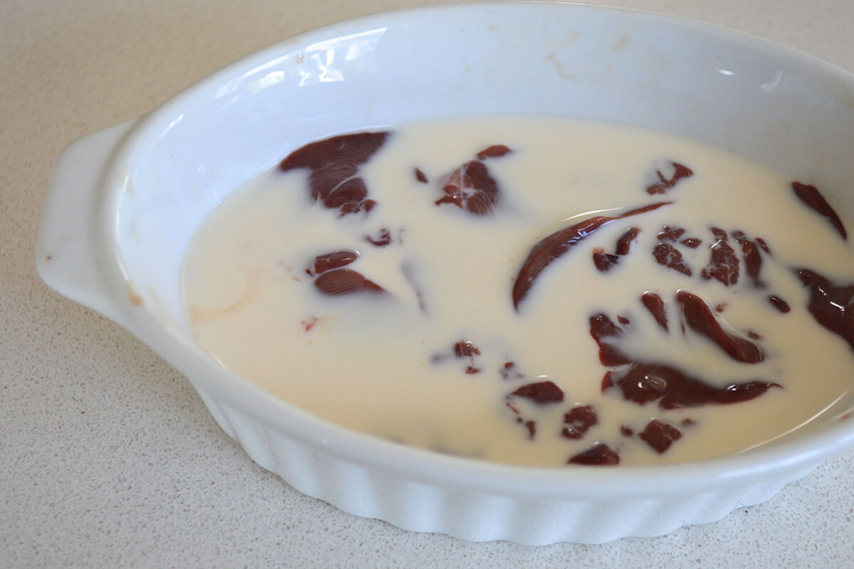 Liver being soaked in a casserole dish of milk