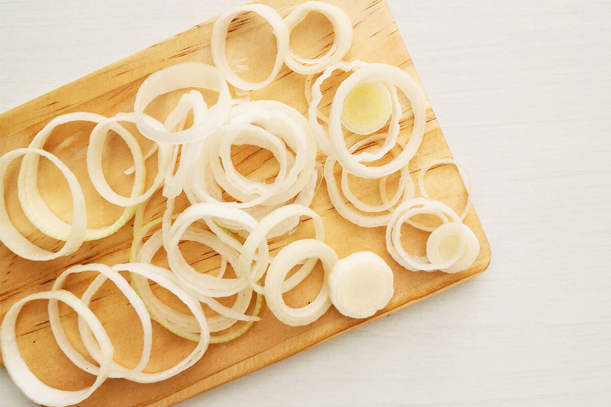 Sliced leeks on a wooden chopping board