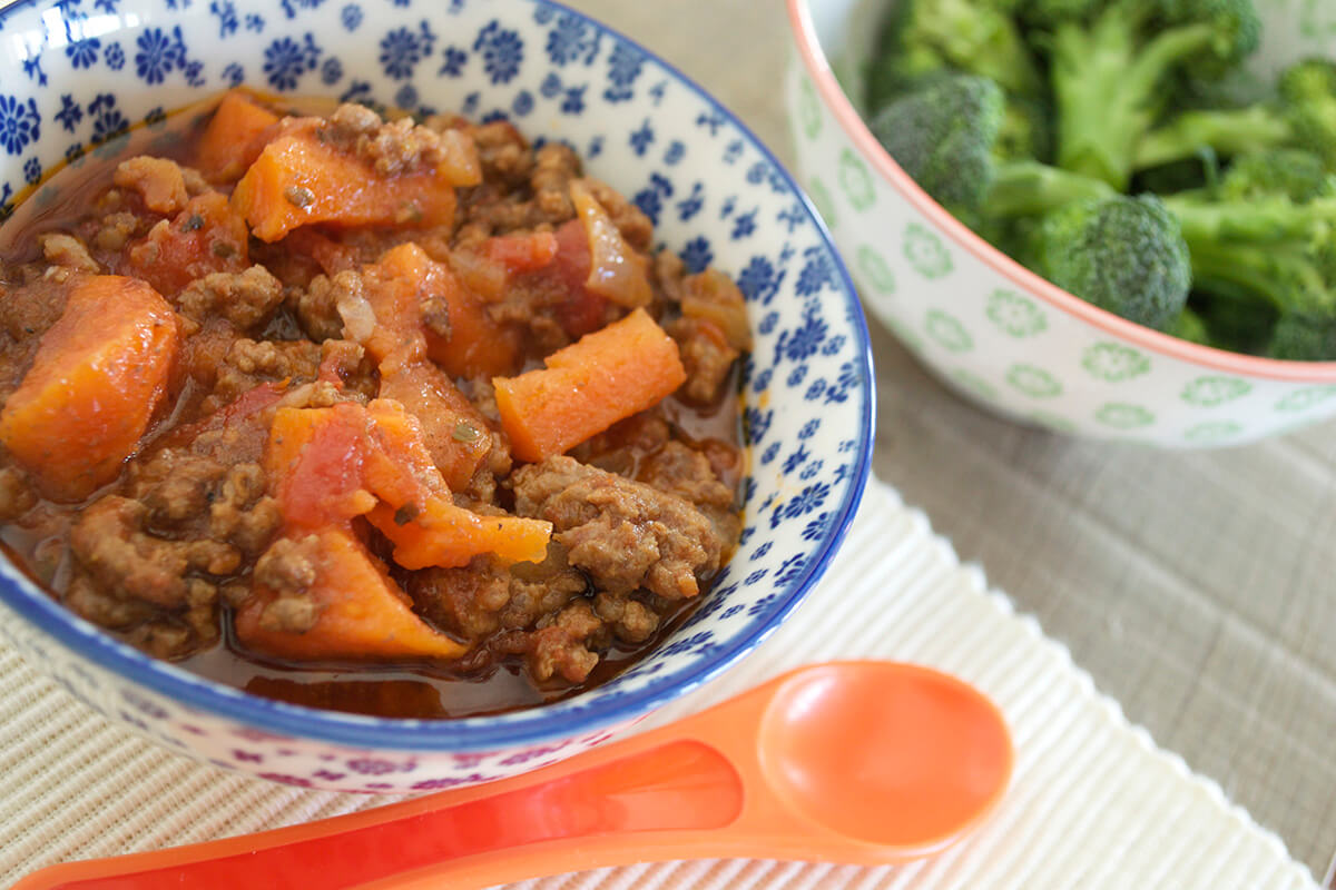 Roasting Tray Ragu in a bowl next to a bowl of broccoli florets